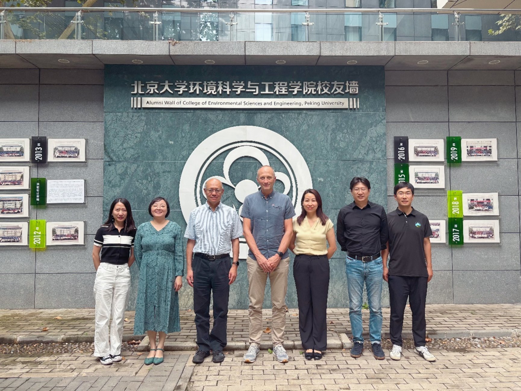 A group of people standing in front of a building
Description automatically generated